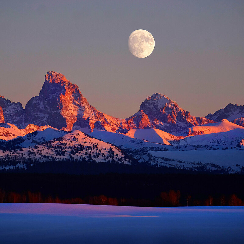 Vollmond über verschneitem Gebirge