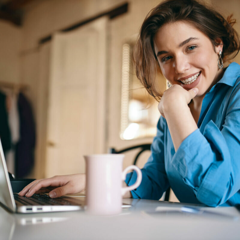 Frau mit Laptop und Kaffeebecher