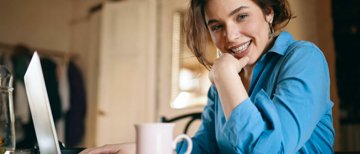 Frau mit Laptop und Kaffeebecher