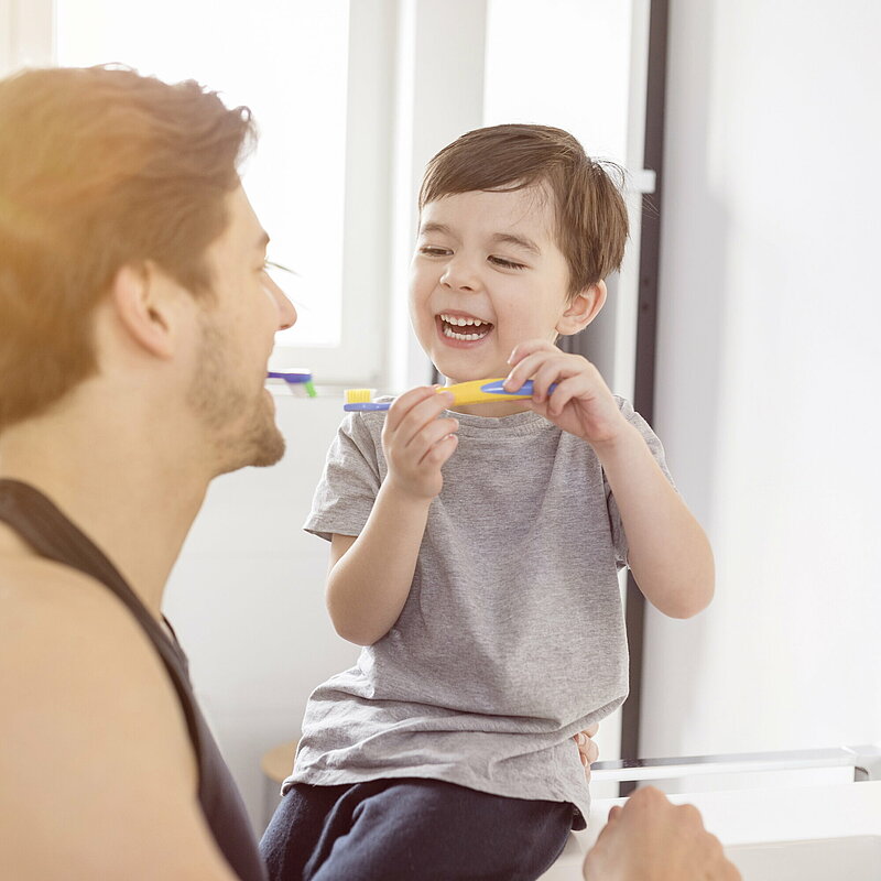 Mann und Junge beim Zähneputzen