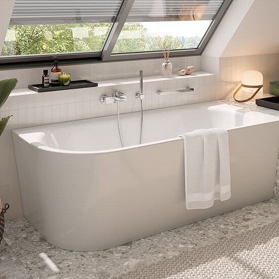 Badewanne unter der Dachschräge, darüber ein Dachflächenfenster. Links eine GRünpflanze, Kosmetika und Dekoartikel auf Ablagen