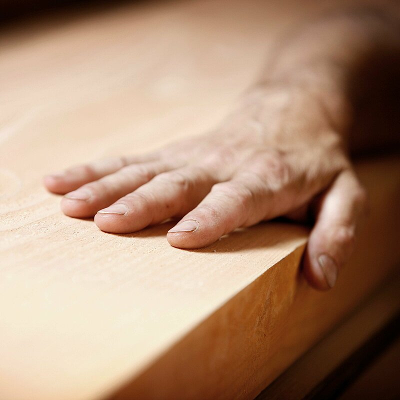 Hand auf Holzplatte